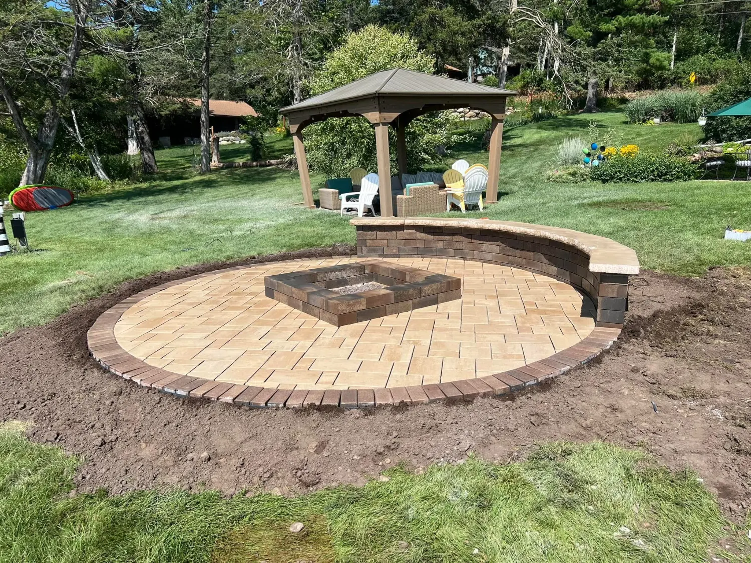 Circular paver patio with a curved seat wall and fire feature