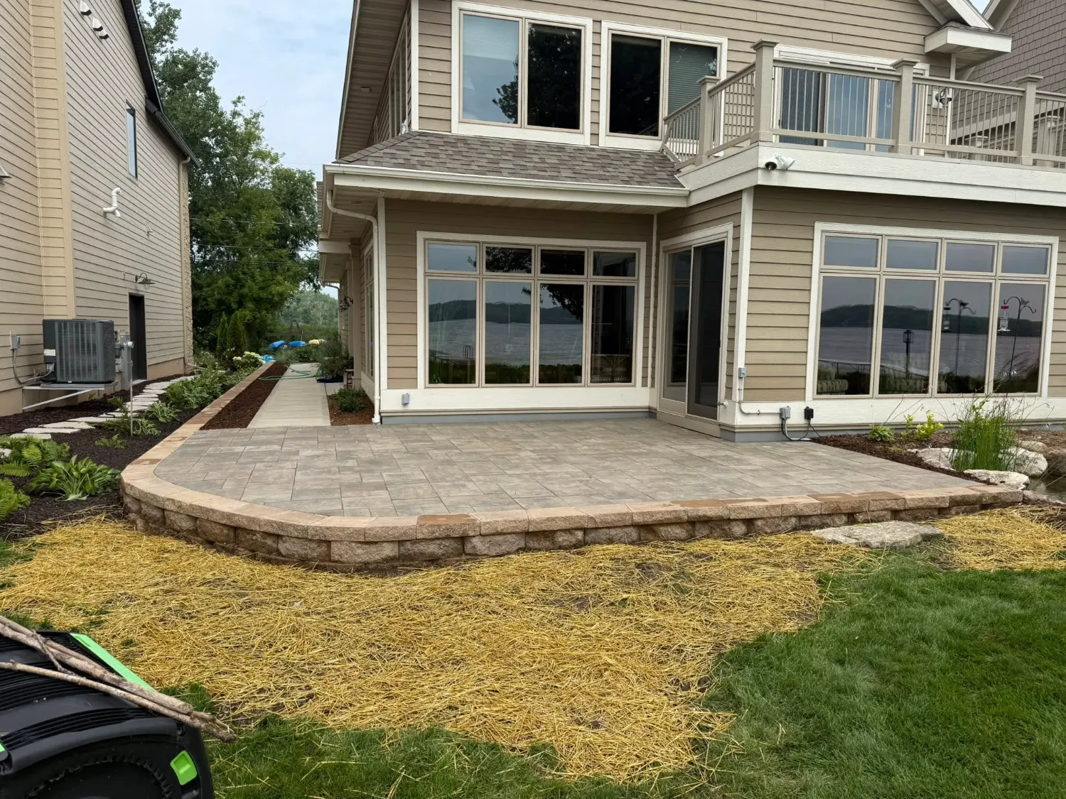 Raised paver patio held by a tumbled block wall at a lakefront home