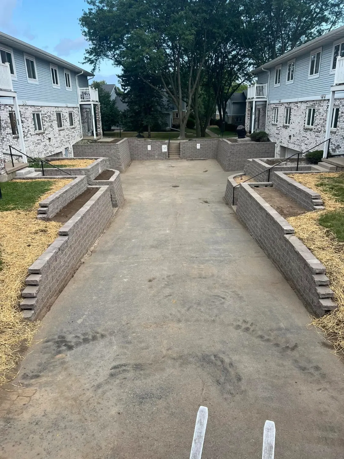 The rebuilt courtyard with tiered segmental block walls, planting beds and new handrails